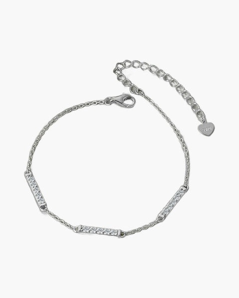 Delicate women's silver 925 bracelet with sparkling cubic zirconia bar links on green surface