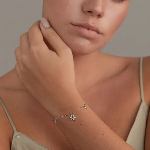 Women's silver chain bracelet with a sparkling flower charm and small round pendants