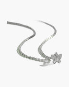 Dainty women's silver 925 necklace with a sparkling cubic zirconia butterfly pendant on green surface