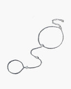 Elegant women's silver 925 hand chain with delicate clover charms on a blue background