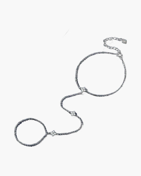 Elegant women's silver 925 hand chain with delicate clover charms on a blue background