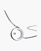 Women's silver 925 necklace with a round moon and star pendant on blue background