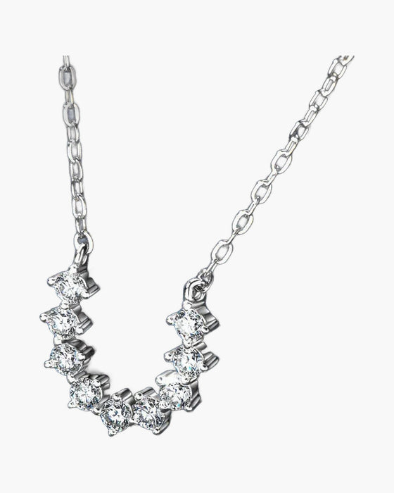 Women's delicate silver 925 necklace with sparkling cubic zirconia stones on a blue background