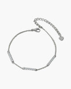 Delicate women's silver 925 bracelet with sparkling cubic zirconia bar links on green surface