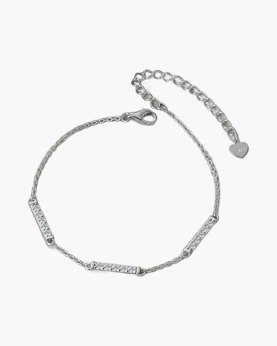Delicate women's silver 925 bracelet with sparkling cubic zirconia bar links on green surface