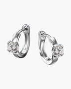 Pair of women's silver huggie hoop earrings with a single round moissanite stone