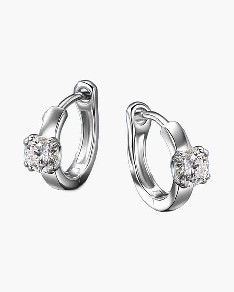 Pair of women's silver huggie hoop earrings with a single round moissanite stone