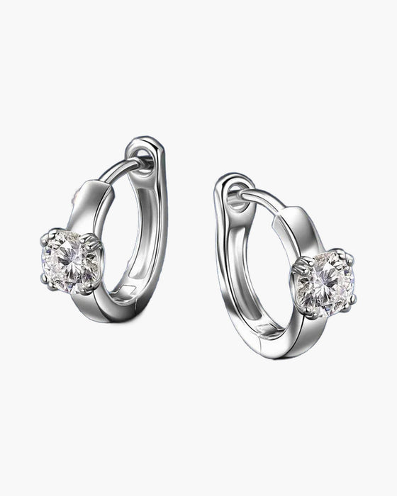 Pair of women's silver huggie hoop earrings with a single round moissanite stone