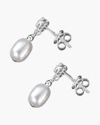 Elegant women's silver 925 stud earrings with dangling white freshwater pearls on blue fabric