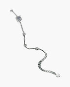 Women's delicate silver 925 bracelet with sparkling cubic zirconia stones on a dark green surface