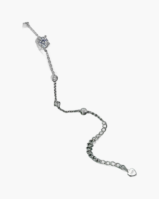 Women's delicate silver 925 bracelet with sparkling cubic zirconia stones on a dark green surface