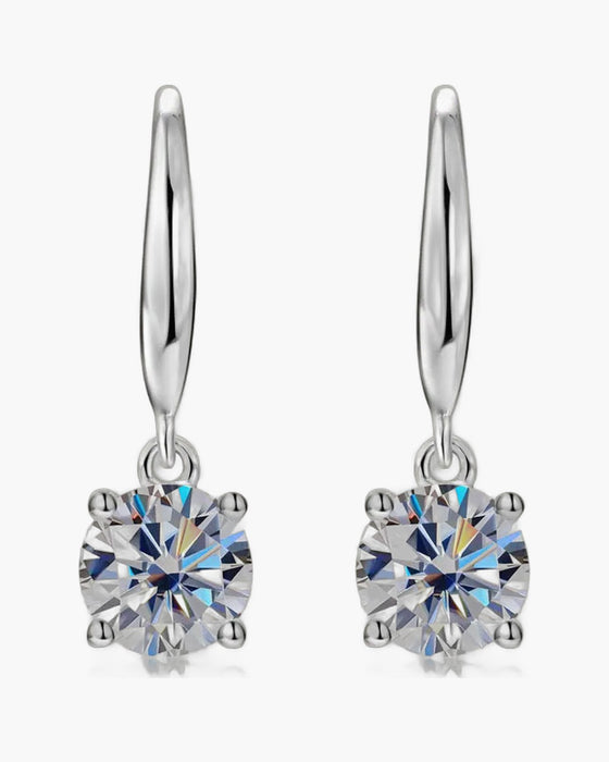 Pair of women's silver dangle earrings with brilliant round solitaire stones in four-prong settings
