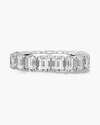 Sparkling women's silver eternity band ring with emerald cut cubic zirconia stones