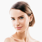 Close-up of a woman wearing sparkling silver graduated moissanite hoop earrings