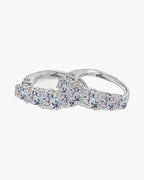 Pair of women's silver hoop earrings with graduated moissanite stones on a white background