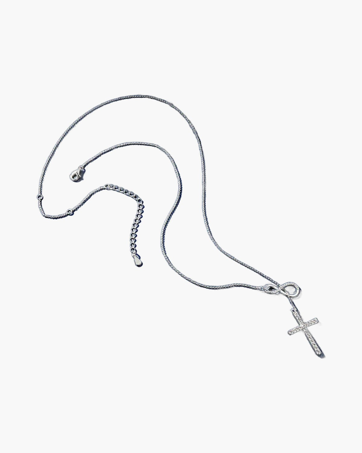 Women's silver 925 necklace with infinity symbol and sparkling cross pendant on blue surface