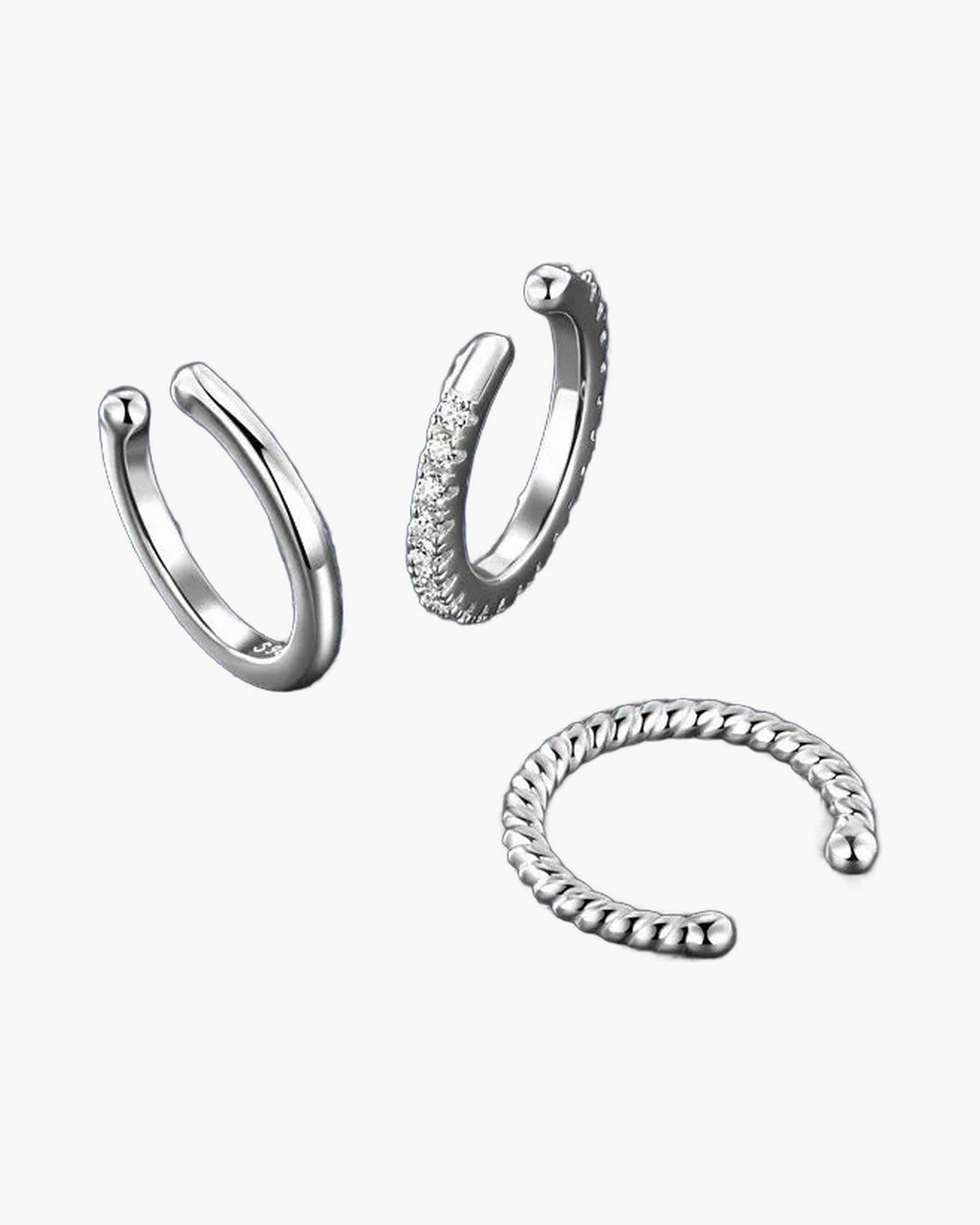 Three women's silver 925 ear cuffs, one with pavé stones, on a blue surface